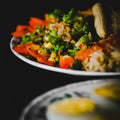 Plated dish with salad and rice on a dark background
