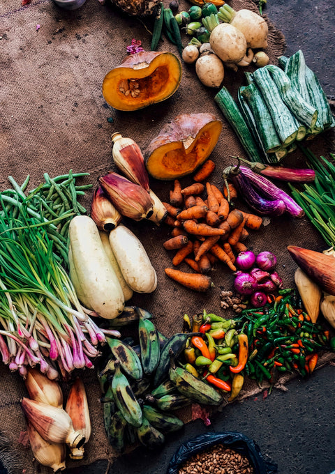 Assorted fresh vegetables on a dark surface